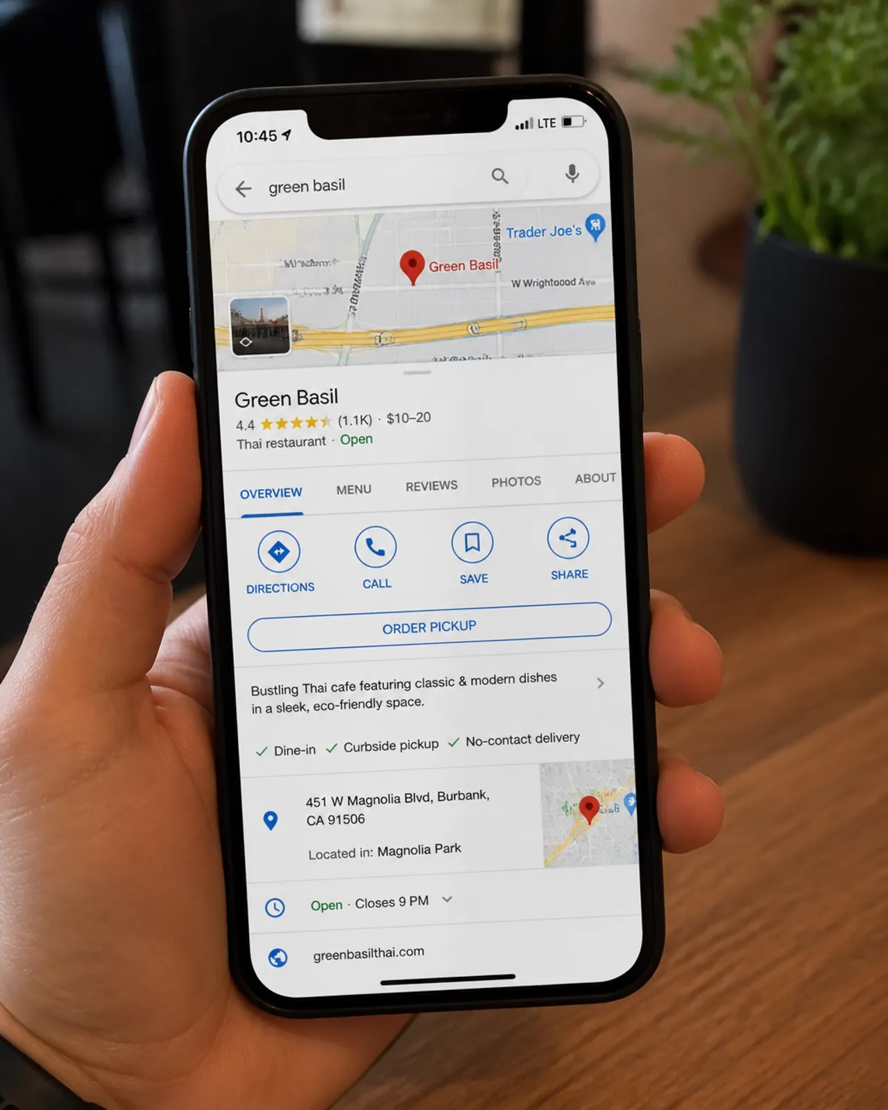 A person's hand holding a phone with a Google Maps call button